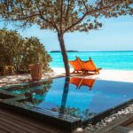 brown wooden lounge chair beside swimming pool during daytime